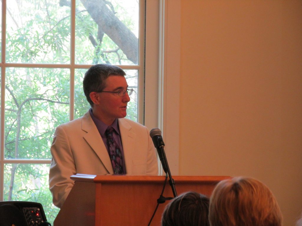 Terri Phoenix speaking about LGBTQIA+ issues at a podium 2016